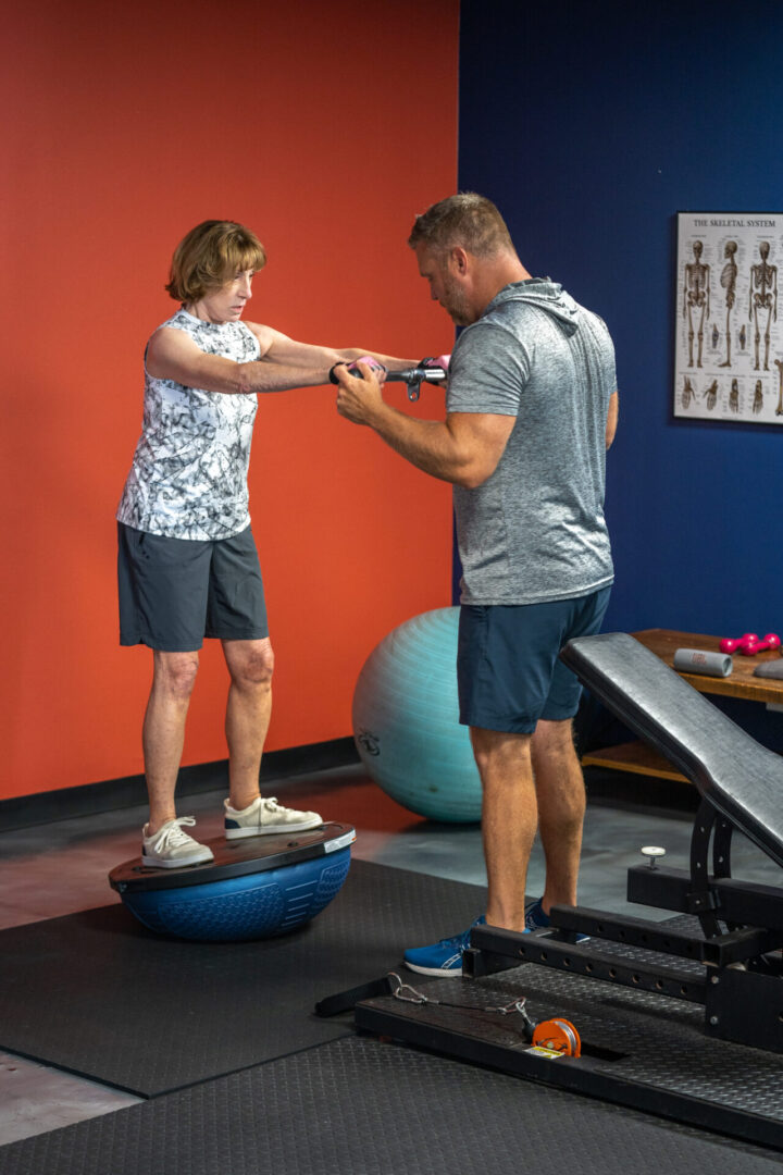 A woman doing squats with a trainer